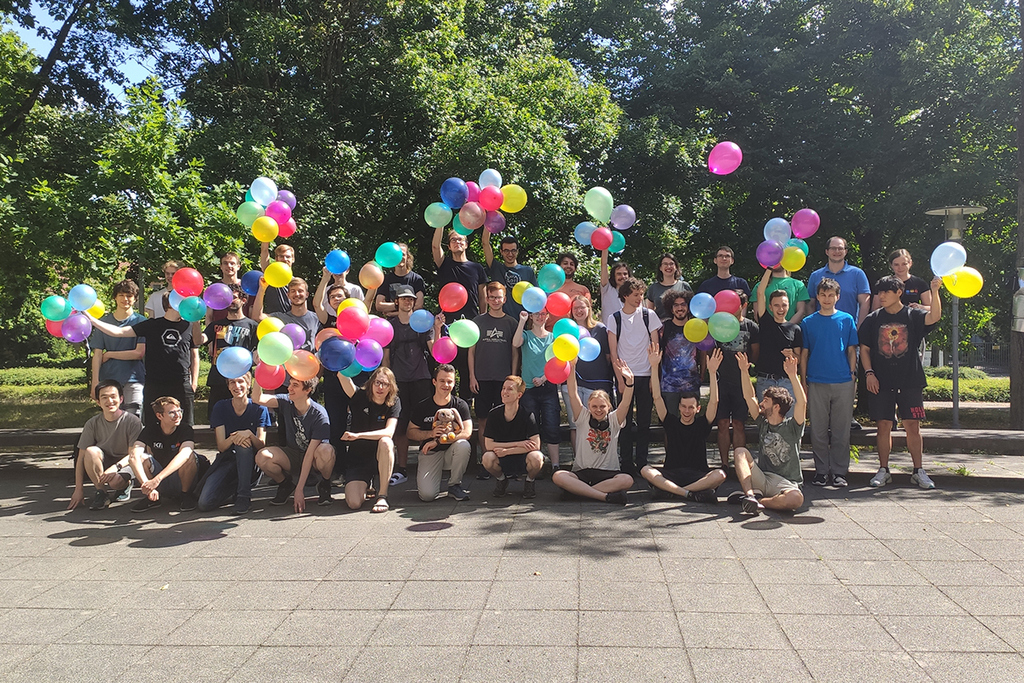 Gruppe von Menschen mit bunten Luftballons im Freien.