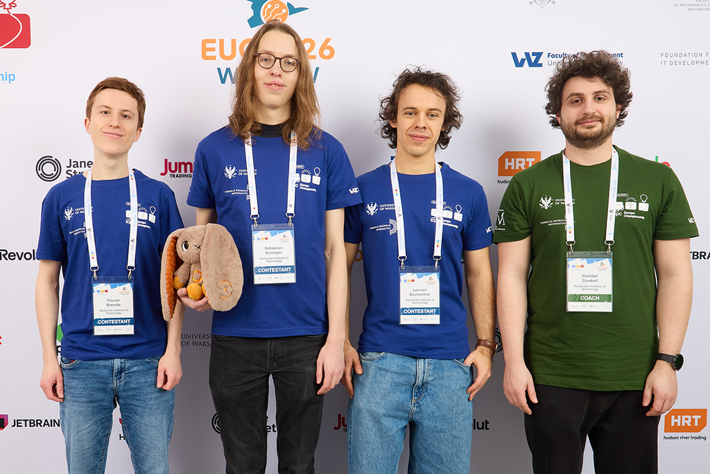 Das Gewinerteam mit ihrem Betreuer. Vier junge Personen mit Namensschildern auf einem Event-Foto, zwei in blauen Shirts, einer in grünem Shirt, einer hält ein Stoffkaninchen.